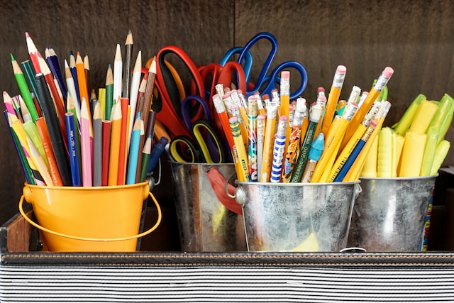 buckets of pencils and other stationary on a shelf